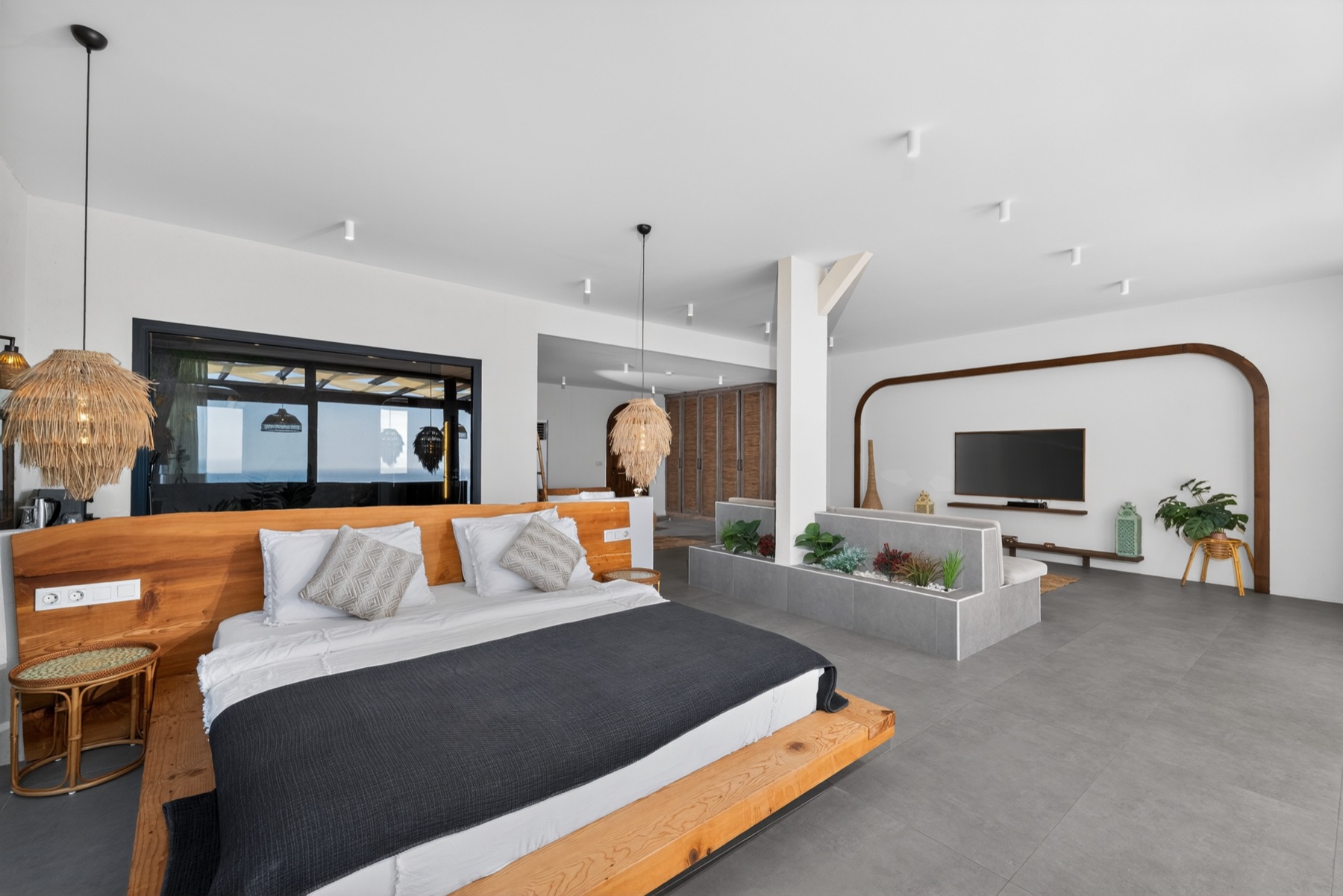 Villa yatak odası; başucunda kemerli niş, yumuşak sabah ışığı.